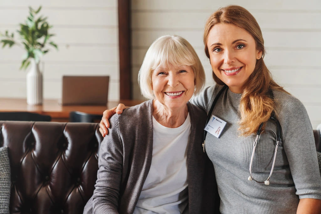 support worker posing with a elderly woman