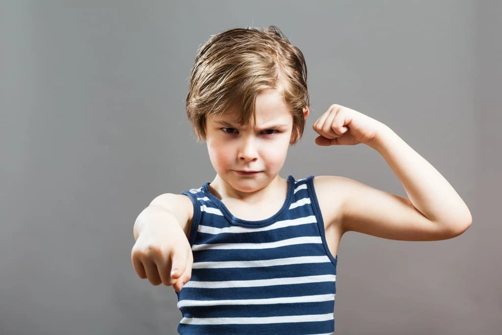 young boy flexing muscles