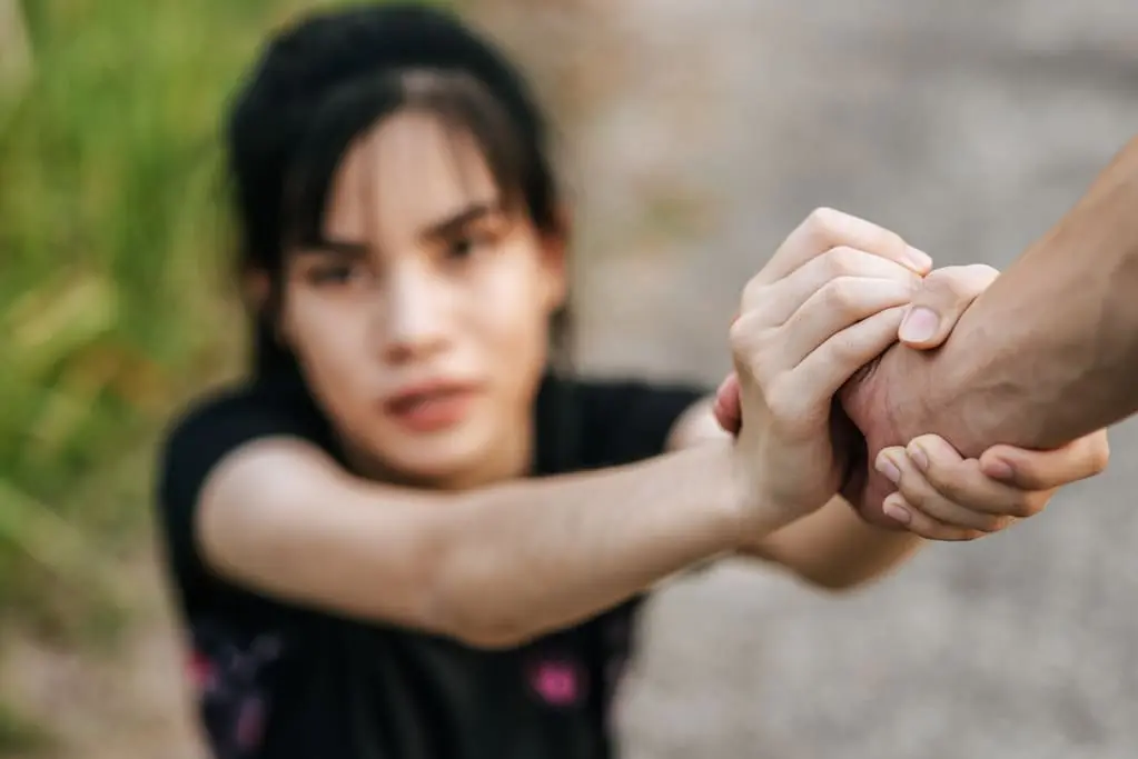 girl holding a man's hand in reach for help