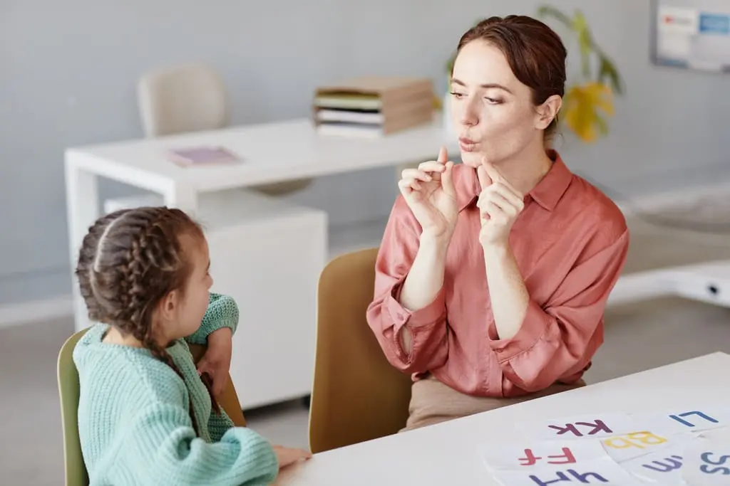 speech therapists exercising with an autistic girl