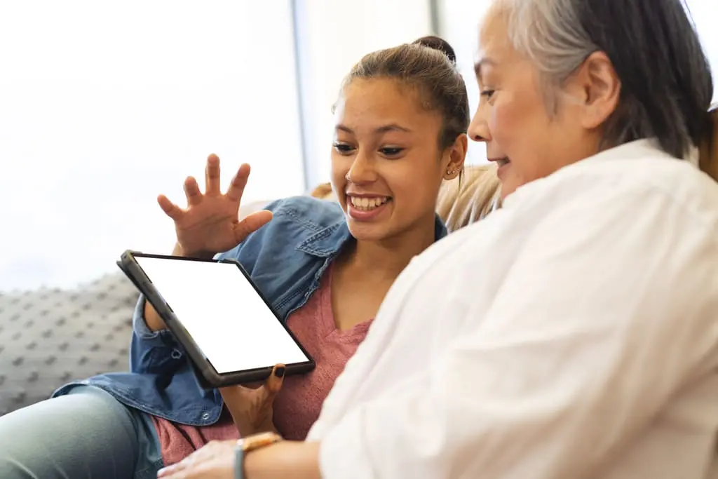 support worker with elderly woman working on tablet