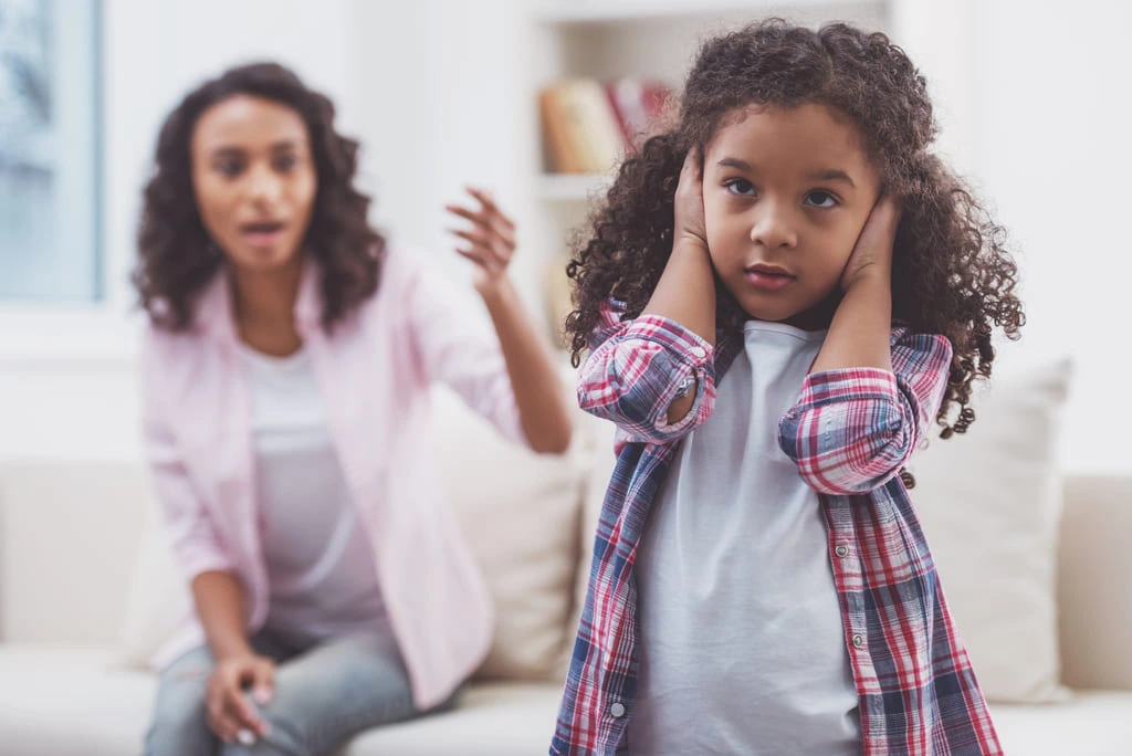 daughter covering her ears not listening to mother